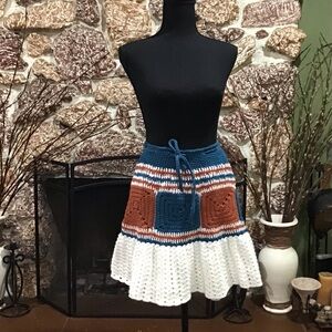 crocheted 🧶 skirt with “granny square” pattern and ruffled hem.